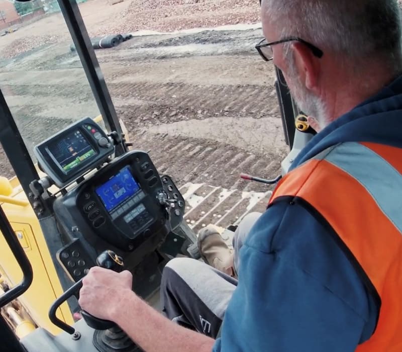 Inside view of McAullife team member operating yellow remediation machinery.